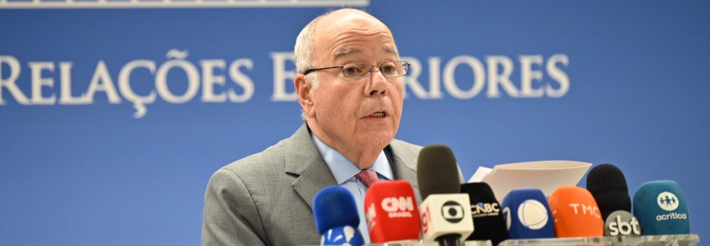 Ministro Mauro Vieira (Relações Exteriores) durante declaração à imprensa em Brasília, com painel azul do ministério ao fundo, escrito Relações Exteriores