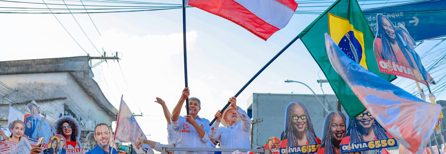 Jeronimo Rodrigue e presidente Lula balançam bandeiras da Bahia e do Brasil em cima de trio elétrico durante comício na Bahia