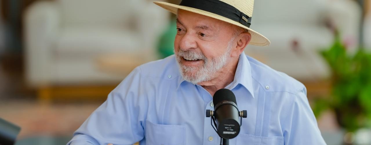 Lula de camisa azul e chapéu estilo Panamá, em sala no Palácio da Alvorada, sentado em frente a uma mesa e com as mãos apoiadas sobre ela