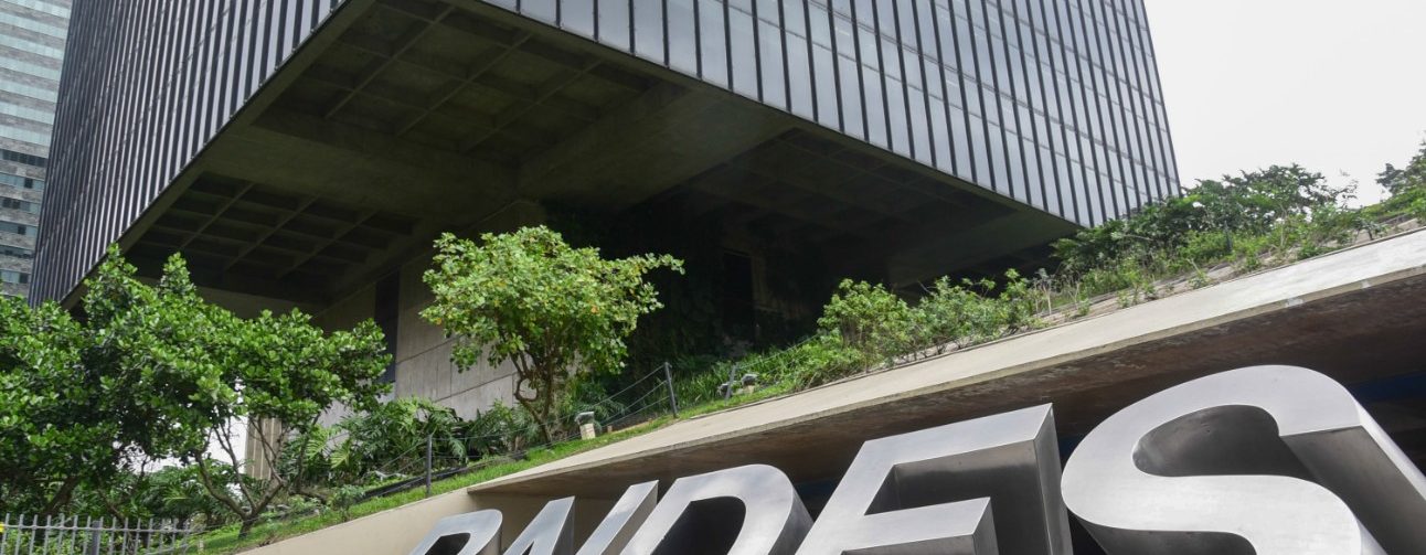Imagem da sede do BNDES com letreiro do banco em primeiro plano